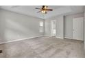 Cozy main bedroom with a ceiling fan, plush carpet, and neutral paint, leading to a walk-in closet at 1138 School Side Dr, Lithonia, GA 30058