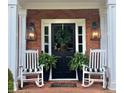 Charming front porch with classic rocking chairs, decorative lanterns, and a welcoming wreath on the front door at 3532 W Hampton Nw Dr, Marietta, GA 30064
