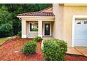 Inviting front entrance featuring a decorative door, manicured landscaping, and a cozy, covered porch at 128 Garden Walk, Stockbridge, GA 30281