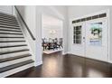 Elegant foyer with dark wood floors, stairs, and a view into the formal dining room at 2385 Saddle Brook Trce, Cumming, GA 30040