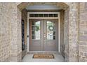 Inviting double front doors framed by brick with a welcoming wreath and 'Hello' mat at 2385 Saddle Brook Trce, Cumming, GA 30040