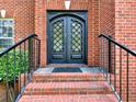 Elegant double front door with decorative metalwork and brick staircase with black handrails at 2725 Bailey Ne Pl, Conyers, GA 30013