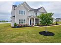 Well-maintained front yard with a gray home, fresh landscaping, and green grass at 105 Marchmont Dr, Locust Grove, GA 30248