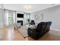 Cozy living room with a fireplace, hardwood floors, and large windows with natural light at 110 Finchley Dr, Roswell, GA 30076