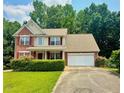 Beautiful two-story home with brick and siding, complemented by mature trees and a well-manicured lawn at 5783 Poppy Tree Ln, Tucker, GA 30084