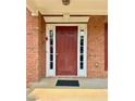 Classic red front door with sidelights, framed by brick and white trim for a welcoming entrance at 5783 Poppy Tree Ln, Tucker, GA 30084