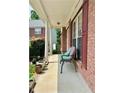 Inviting front porch with cozy seating, brick accents, and a glimpse of the home's charming exterior at 5783 Poppy Tree Ln, Tucker, GA 30084