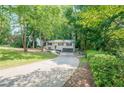 Landscaped front yard and long driveway leading up to this beautiful home nestled among mature trees at 2825 Shea Sw Way, Marietta, GA 30060