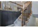 Modern staircase featuring wood treads, black metal railings, and contrasting black wainscoting at 2825 Shea Sw Way, Marietta, GA 30060