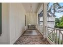Inviting covered porch with a cozy swing, brick flooring, and white railings, perfect for relaxing outdoors at 4250 Summit Dr, Marietta, GA 30068