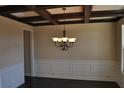 Elegant dining room with dark wood floors, coffered ceiling, wainscoting, and a chandelier at 920 Crescent Ridge Dr, Buford, GA 30518