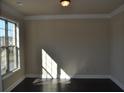 Sunlit living room with dark hardwood floors, neutral walls, and large windows at 920 Crescent Ridge Dr, Buford, GA 30518