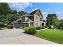 Beautiful home with a three-car garage and a well-manicured lawn and landscaped shrubbery at 203 Crescent Moon Way Way, Canton, GA 30114