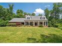 Inviting single Gathering home with a covered front porch, dormer windows, and lush landscaping at 3990 Wesley Chapel Rd, Marietta, GA 30062