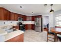 Functional kitchen featuring stainless steel appliances, dark wood cabinets, and tile flooring at 6675 Princeton Park Ct, Lithonia, GA 30058