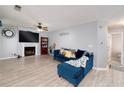 Cozy living room featuring a fireplace, ceiling fan, and comfortable blue sofa at 6675 Princeton Park Ct, Lithonia, GA 30058