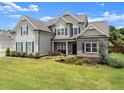 A stunning two-story home with a brick and siding facade, showcasing its beautifully maintained front yard at 7820 Longview Dr, Cumming, GA 30041