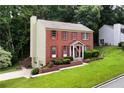 Beautiful brick home with red shutters, a landscaped front yard, and attached garage at 2621 Garland Way, Duluth, GA 30096