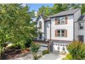 Well-maintained townhouse showcasing neutral siding, dark wood shutters, and an attached garage with brick accents at 884 Edgewater Cir, Marietta, GA 30062