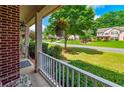Charming front porch with white railings and a view of the landscaped front yard and street at 1120 Bagwell Dr, Kennesaw, GA 30152