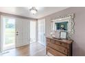 Bright foyer features light-colored walls, hardwood floors, antique cabinet, and decorative mirror and light fixture at 2229 S Van Wert S Rd, Villa Rica, GA 30180