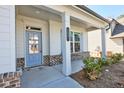 Inviting front porch with decorative columns, brick accents, and a blue front door at 3557 at 3557 Bryant Meadows Cir, Buford, GA 30519