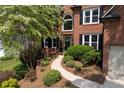 Stunning brick home with mature landscaping and a charming walkway leading to the entrance at 809 Hillcrest Ln, Woodstock, GA 30189