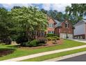 Beautifully landscaped brick home featuring a well-manicured lawn and mature trees at 809 Hillcrest Ln, Woodstock, GA 30189