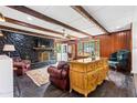 Inviting living area showcasing a stone fireplace, beamed ceiling, and rich wood accents at 2905 Jim Owens Nw Rd, Kennesaw, GA 30152