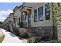Modern townhome exteriors feature brick accents, a sidewalk, neutral paint, and a stylish covered entryway at 297 White St # 1, Marietta, GA 30060