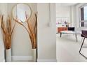 Stylish foyer featuring decorative vases, round mirror, and light hardwood floors at 20 Marietta Nw St # 15D, Atlanta, GA 30303