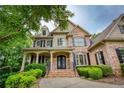 Stately brick home with a covered front porch and elegant glass front doors at 9035 Brixham Ct, Suwanee, GA 30024