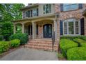 Close up of the front porch with brick steps, iron railings, and decorative front doors at 9035 Brixham Ct, Suwanee, GA 30024