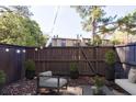 Cozy fenced backyard with string lights, mature trees, and an inviting seating area at 13 Ivy Ne Sq, Atlanta, GA 30342
