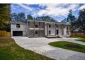 An impressive two-story brick home with prominent columns and a newly paved concrete driveway at 4395 Woodland Brook Se Dr, Atlanta, GA 30339
