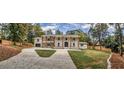 Expansive shot of a two-story home displaying the front facade, landscaping, and a large driveway at 4395 Woodland Brook Se Dr, Atlanta, GA 30339