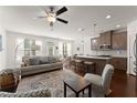 Open-concept living room featuring a ceiling fan, sofa, and adjacent kitchen at 61 N Auburn Landing Pl, Auburn, GA 30011
