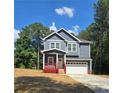 Two-story home with navy siding, white trim, a red porch, an attached two car garage and nice landscaping at 102 Neal Ave, Stockbridge, GA 30281