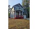 Two-story home with navy siding, white trim, a red porch, an attached two car garage and nice landscaping at 102 Neal Ave, Stockbridge, GA 30281