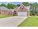 Inviting brick home with a spacious driveway, two-car garage, and well-maintained front yard at 1125 Lewis Ridge Cir, Lawrenceville, GA 30045