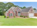 Beautiful brick home boasts a lush front lawn and a two-car garage, enhancing its curb appeal at 1125 Lewis Ridge Cir, Lawrenceville, GA 30045