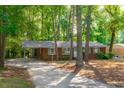 Lovely one-story brick home featuring a carport, landscaping, and mature trees at 1671 Drayton Woods Dr, Tucker, GA 30084