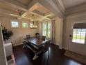 Bright dining room with coffered ceilings, chandelier, and an oversized wooden dining table at 442 Snow Owl Way, Lawrenceville, GA 30044