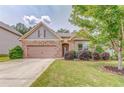 Charming home featuring a stone facade, two-car garage, manicured lawn, and meticulously maintained landscaping at 105 Silver Trce, Dallas, GA 30157