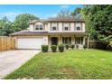 Traditional two-story home with a well-manicured front lawn, mature trees, a two car garage and shuttered windows at 493 Whaleys Lake Dr, Jonesboro, GA 30238