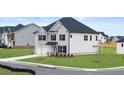 Side view of a two-story home with brick and siding, showcasing the attached garage and manicured lawn at 1179 Blue Juniper Cir, Loganville, GA 30052