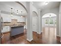 Open kitchen featuring an island, white cabinets, and hardwood floors at 1239 Grampian Pass # 11, Marietta, GA 30008