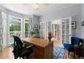 Spacious home office with French doors, hardwood flooring, and a comfortable seating area at 220 Webley Ln, Alpharetta, GA 30022