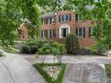 Charming brick home with black shutters, mature trees, and beautiful landscaping at 127 Roe Hampton Ln Ln, Stone Mountain, GA 30087