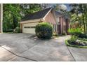Spacious driveway leading to a two-car garage, framed by mature trees and meticulous landscaping at 127 Roe Hampton Ln Ln, Stone Mountain, GA 30087
